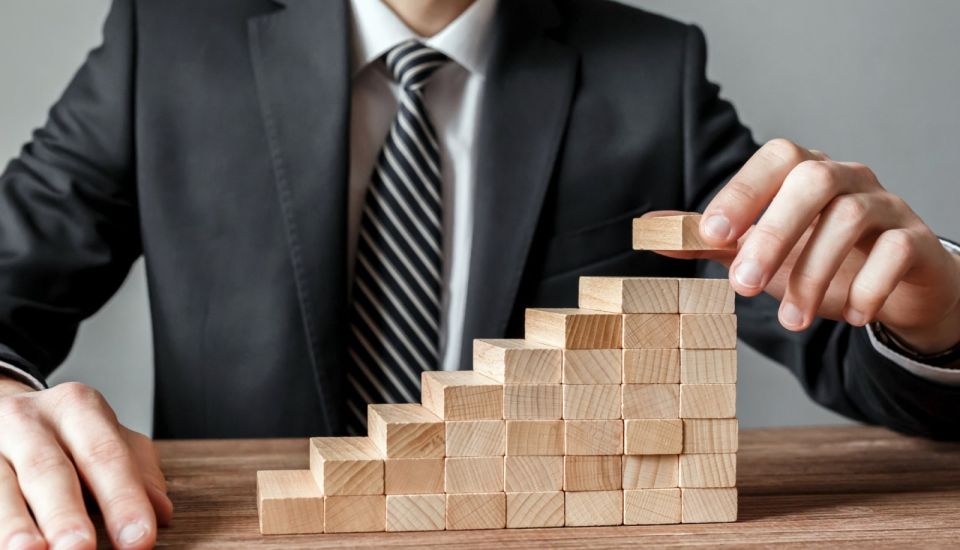Business person stacking building blocks