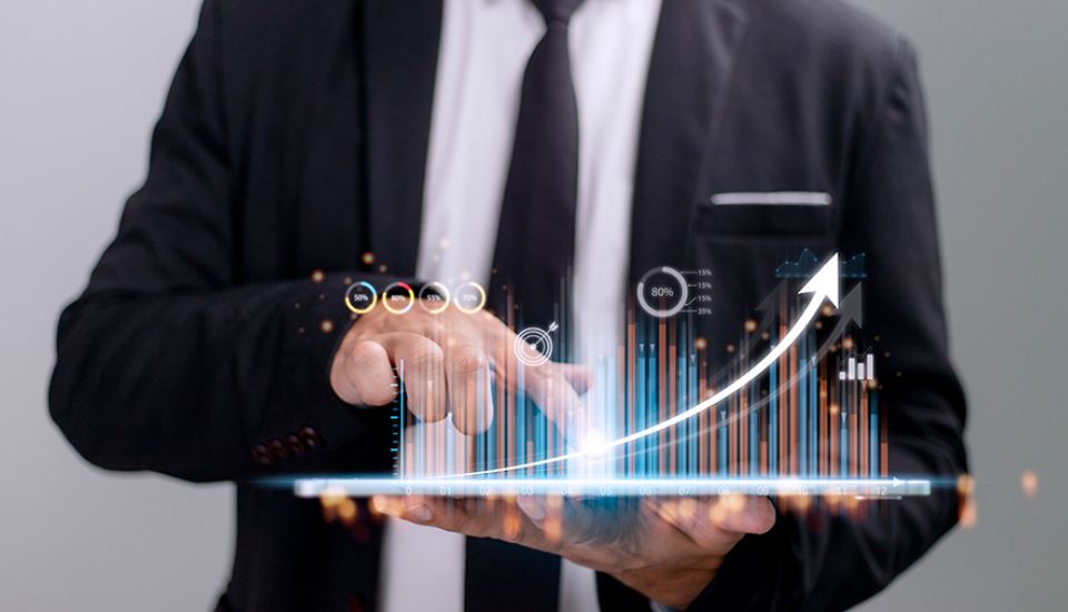 A man using a tablet showing a business graph